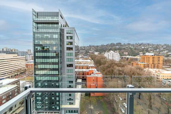 A modern glass building stands tall in a cityscape.