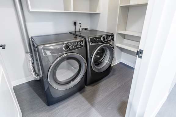 Two front loading washing machines in a laundry room.