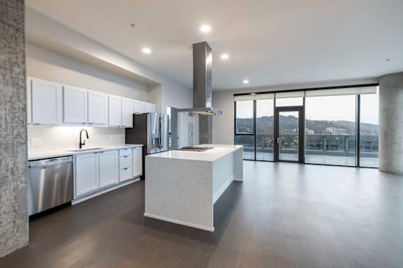 A modern kitchen with a large island and stainless steel appliances.