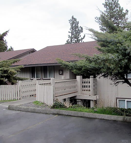 A house with a brown roof and a white fence.
