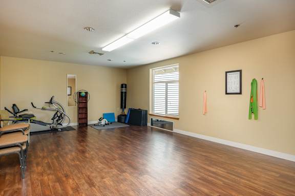 A room with a wooden floor and exercise equipment.