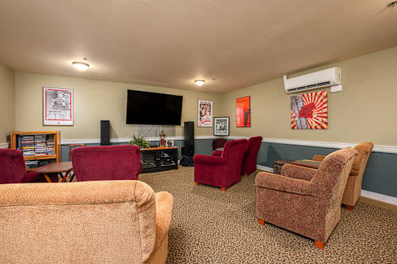 A living room with a couch, chairs, and a television.