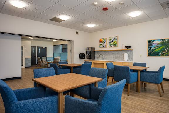 A conference room with blue chairs and a wooden table.