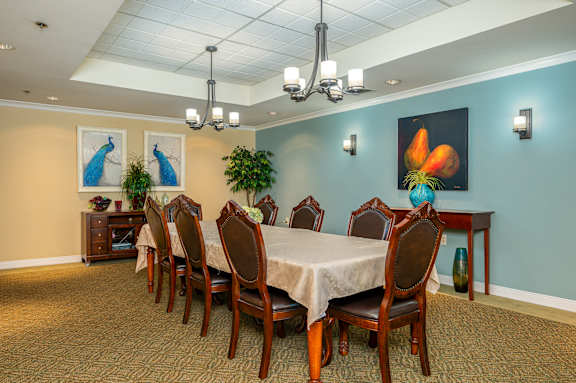 A dining room with a long table and chairs.