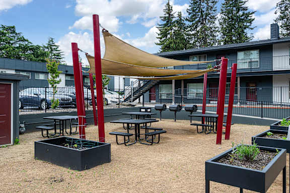 A playground with red poles and a yellow canopy.