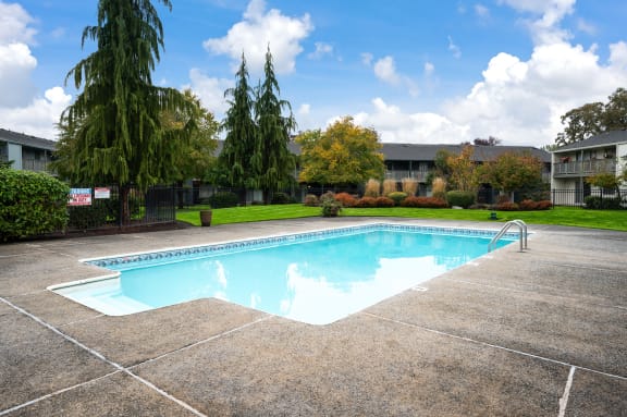 a swimming pool in a yard with apartments in the background