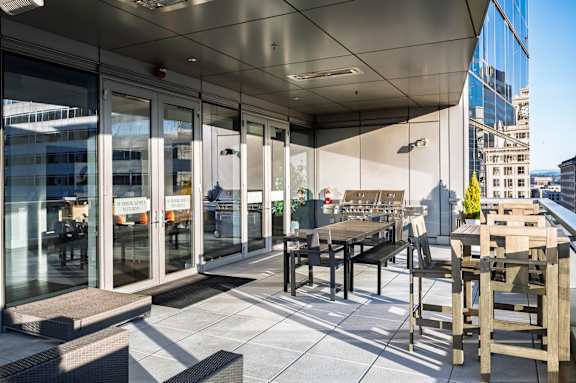 A glass and wood patio with a table and chairs.