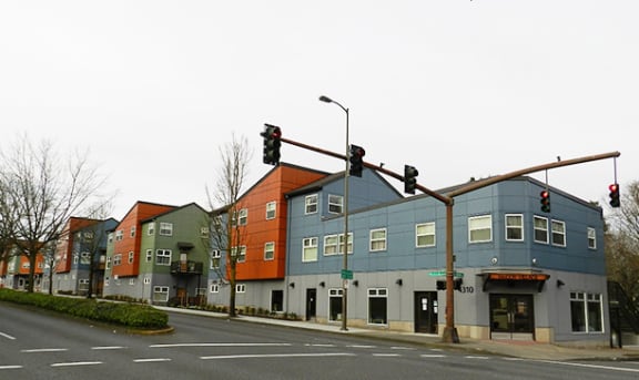 a row of buildings on a street corner at a traffic light