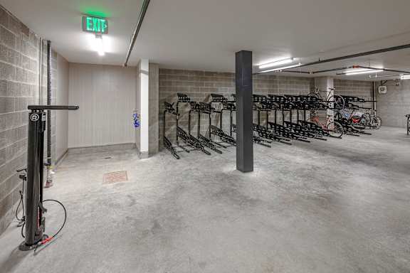 A bike parking area with a green exit sign.
