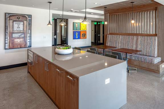 A modern kitchen with a wooden island and a bench seating area.