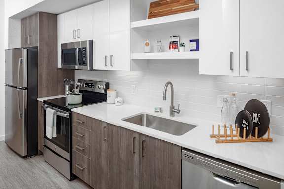 A modern kitchen with a stainless steel refrigerator and a white countertop.