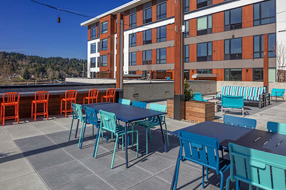 A patio with blue chairs and tables.