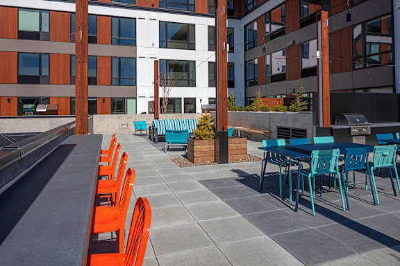 A patio with orange chairs and tables.