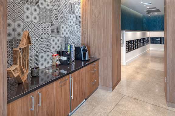 A kitchen with wooden cabinets and a black counter top.