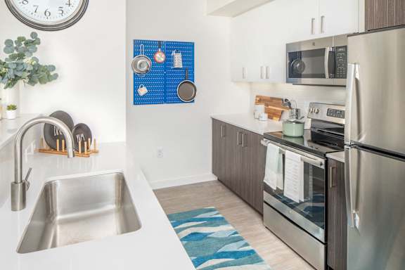 A modern kitchen with a stainless steel refrigerator, microwave, and oven.