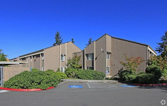 A large building with a parking lot in front.