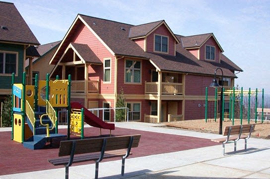a playground in front of a large house