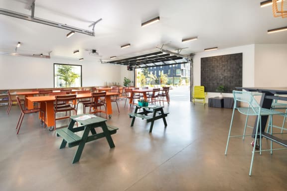 a room with tables and chairs and a chalkboard on the wall