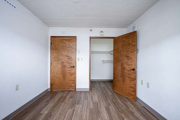 A room with two wooden doors and a white wall.