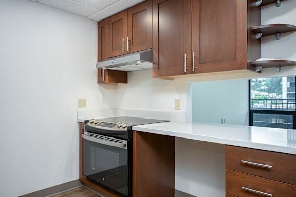 A kitchen with brown cabinets and a white countertop.