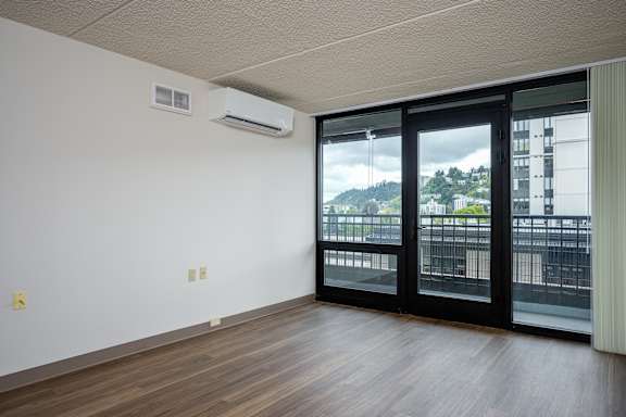 A room with a sliding glass door leading to a balcony.