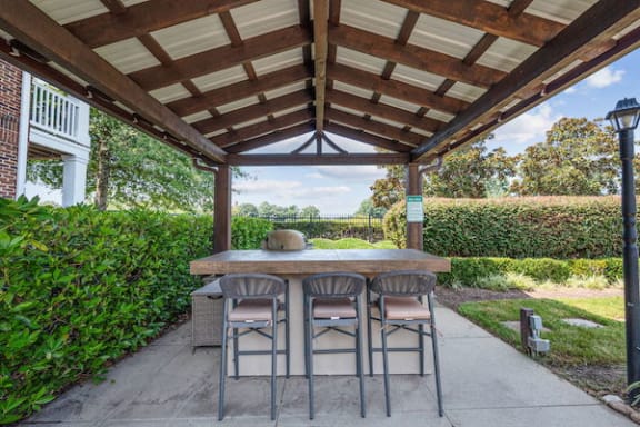 Poolside grillinga area with stainless steel grill and bar with chairs