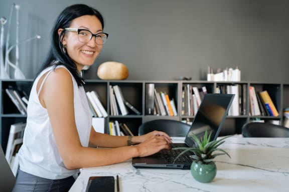 a friendly leasing agent working at a desk on a laptop