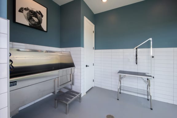 a laundry room with a sink and ironing board at Canopy Park Apartments, Alabama