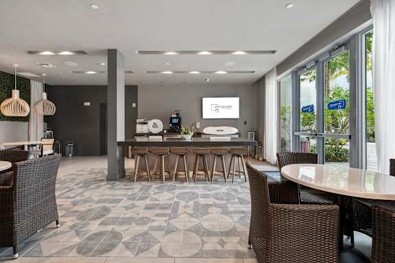 A modern dining area with a long table surrounded by chairs.