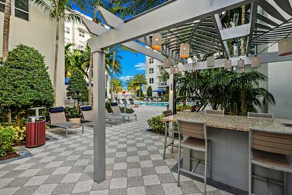 A patio with a bar and chairs under a canopy.