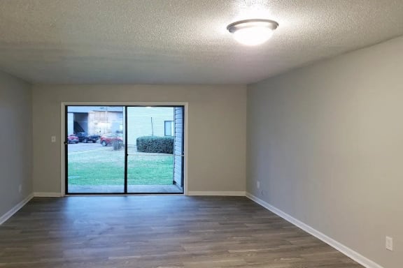 Empty Living Room with a Sliding Door at Woodland Villas Apartments in Jasper, AL