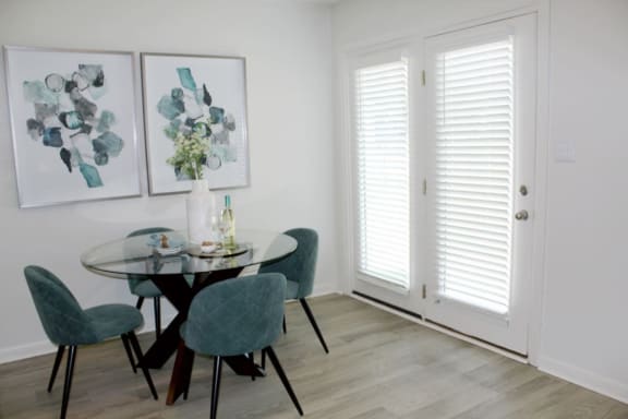 a dining room with white walls and a glass table  at Huntsville Landing Apartments, Huntsville, 35806
