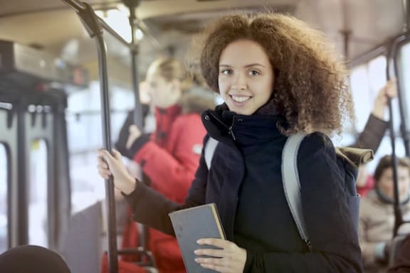 a young woman smiling while riding public transportation
