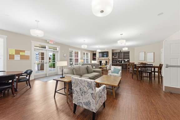 A spacious living room with a variety of furniture and a large window.