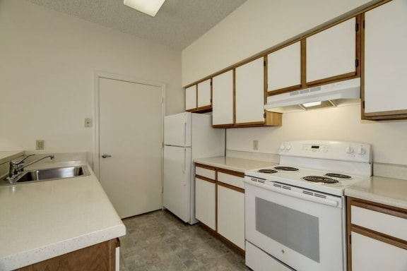 a kitchen with a white refrigerator freezer next to a stove top oven