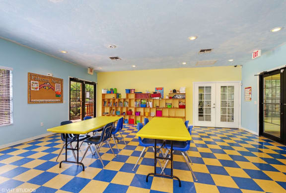 children's activity center with tables, chairs, and bookshelf