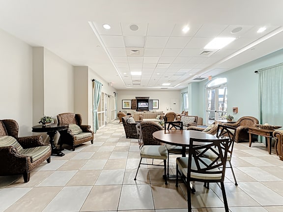 A spacious clubhouse lounge area with a variety of furniture including chairs, couches, and tables.