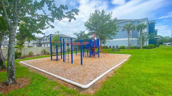 Outdoor playground with slides, latter's surrounded by native landscaping