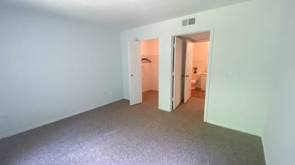 Carpeted Bedroom with folding closet door, bedroom door leads to hall and bathroom