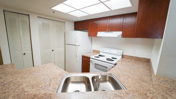 Kitchen with White Appliances, Wood Cabinets and Tan Counters