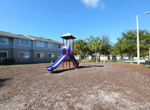 A playground with a purple slide and a white canopy.