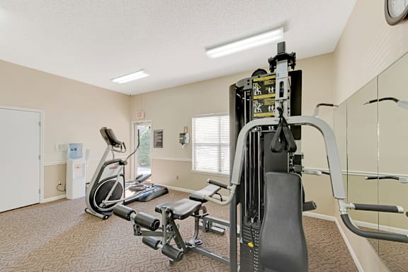 A gym with a treadmill, elliptical trainer and weights at Fox Hollow Apartment Homes, North Carolina, 27265