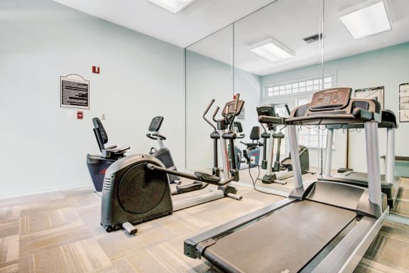 Fitness center with cardio machines and large mirror wall