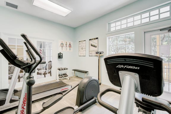 Fitness center with cardio equipment, dumb bell free weights, scale and large windows
