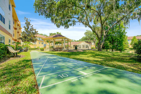 Shuffleboard court overlooking the covered grill area with benches and native landscaping