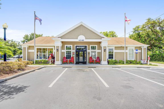 Clubhouse entrance with parking lot, flag poles and native landscaping