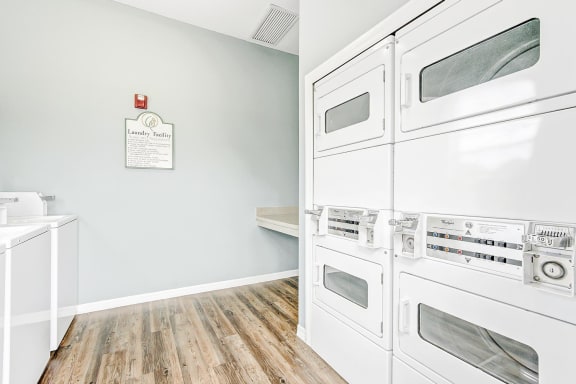 Laundry center with washer and dryers and wood style flooring