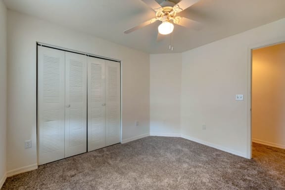 Carpeted Bedroom with Ceiling Fan Window and Sliding Closet