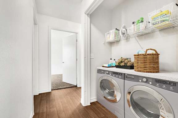 A laundry room with a basket on top of the washer.