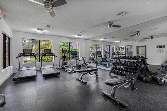 A spacious gym with treadmills, weights, and exercise equipment.